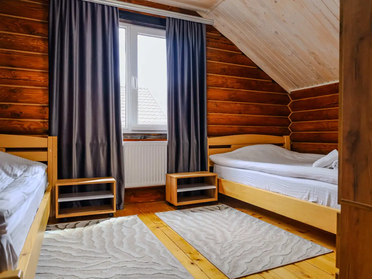 Світла мансардна кімната з килимками