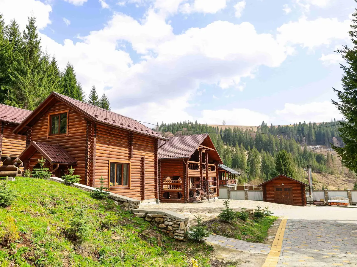 Фасад готелю з гойдалкою на території